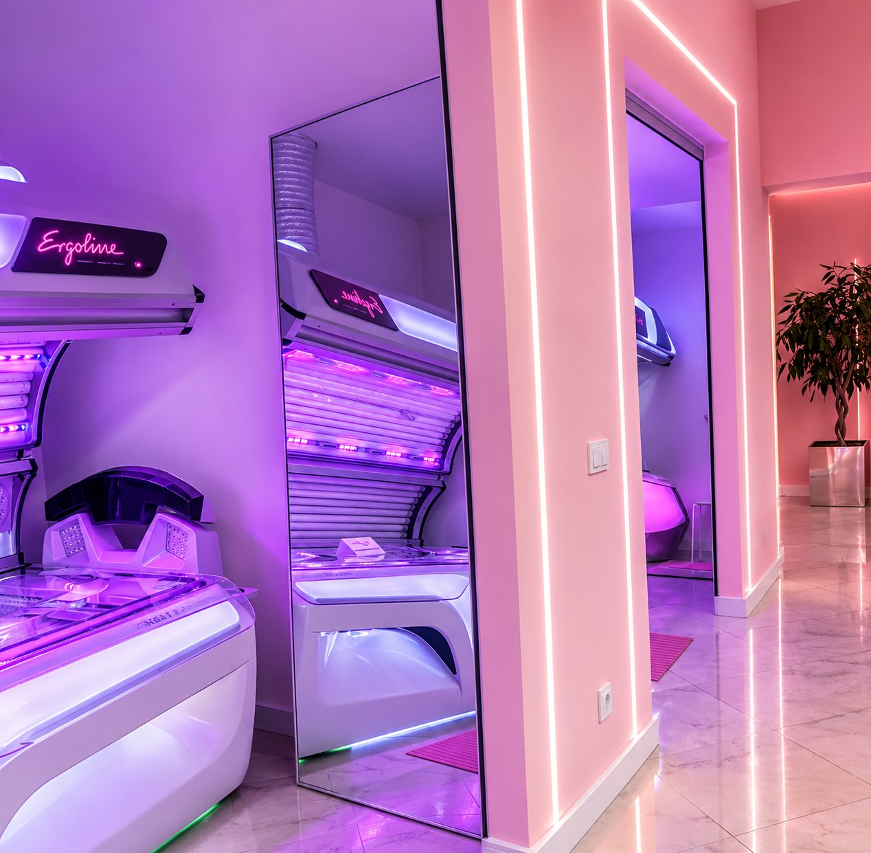 Wnętrze PIK Solarium z łóżkiem opalającym, lustrem i różowo podświetlonym wejściem