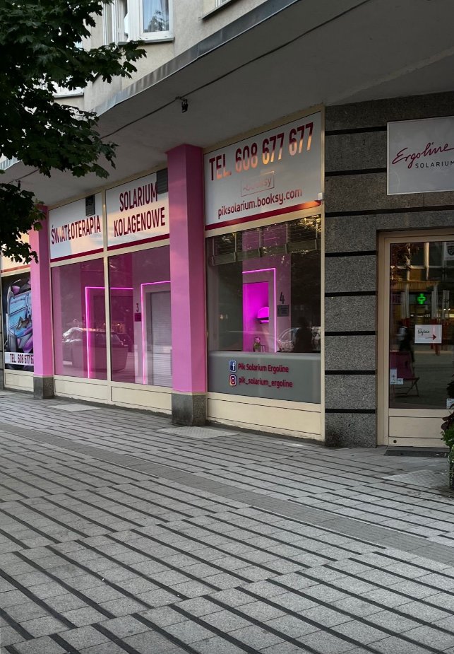 Witryna PIK Solarium w świetle dziennym z różowym oświetleniem i chodnikiem przed wejściem